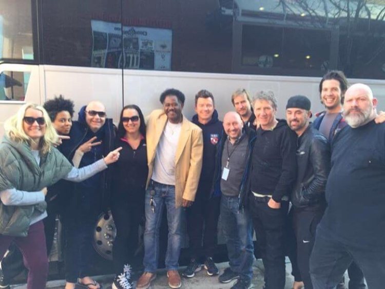 A group of people posing for a photograph in front of a charter bus