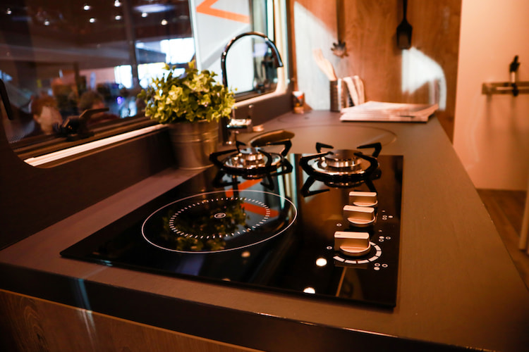 a stovetop and sink inside a tour bus