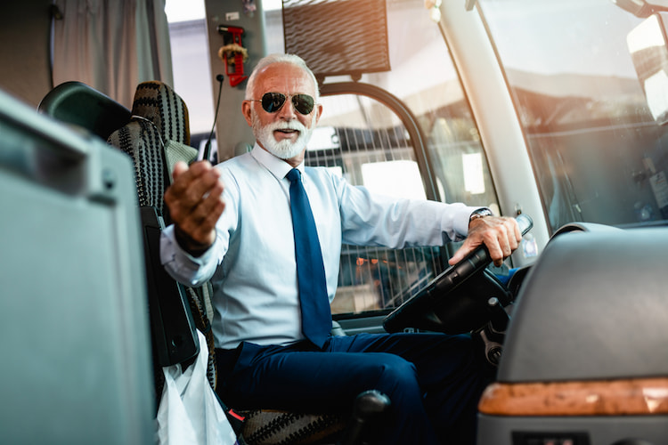 a friendly tour bus driver sits in the driver's seat, ready for a trip