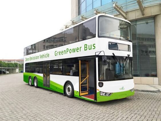 a double-decker electric bus parked outside a building