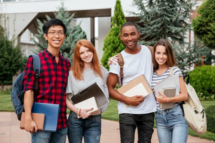 four college students holding books on an LA college campus