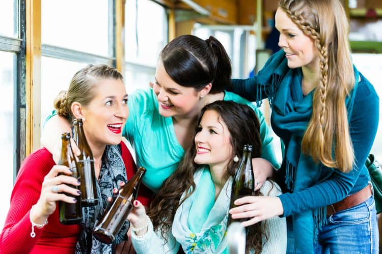 A group of women smiling and drinking beer