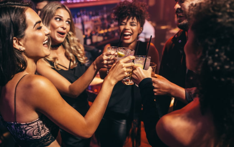 a group of friends toast drinks at a nightclub