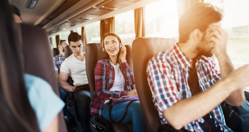 a woman listens to music with headphones on a charter bus