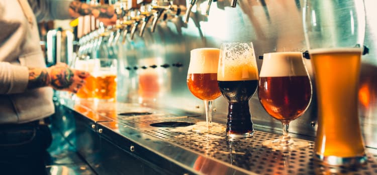 person pouring beer at a bar from tap