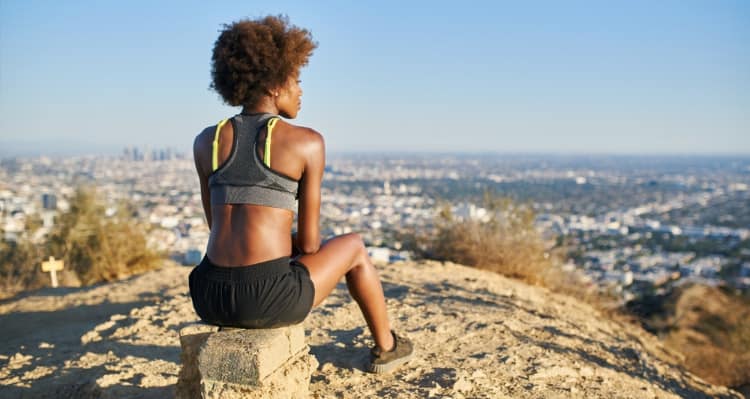 A girl sitting on top of a mountain