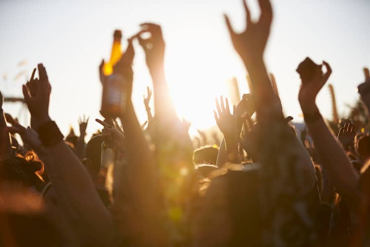 a group of music fans raise their hands at a performance at Austin City Limits