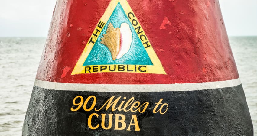 the painted stone that marks the southernmost point of the contiguous United States, which reads "The Conch Republic, 90 miles to Cuba"