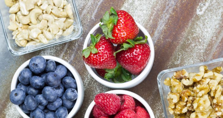 some snack ideas for a long bus ride-- cashews, strawberries, blueberries, and walnuts