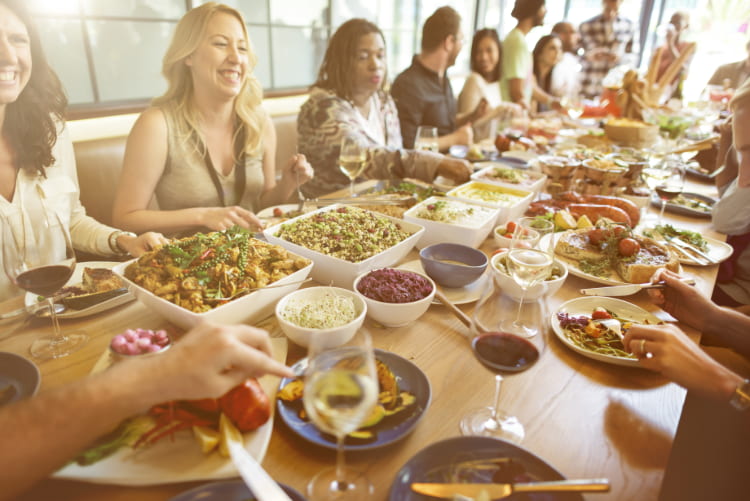 a large group of people share a meal at a restaurant