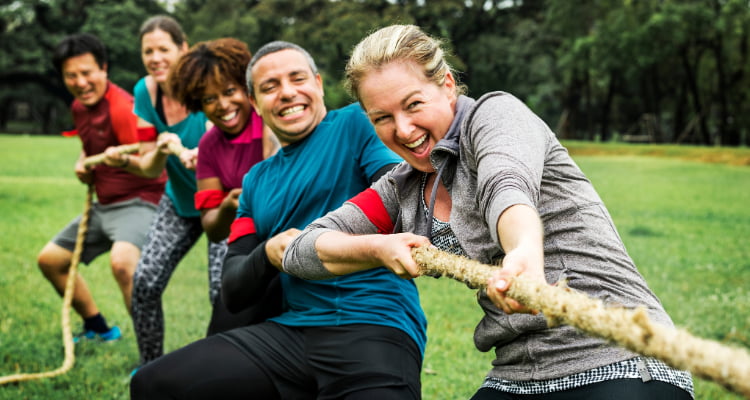 coworkers play tug-of-war at a team-building event