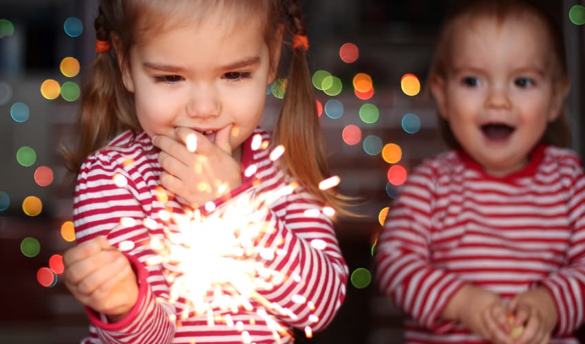 two children play with sparklers