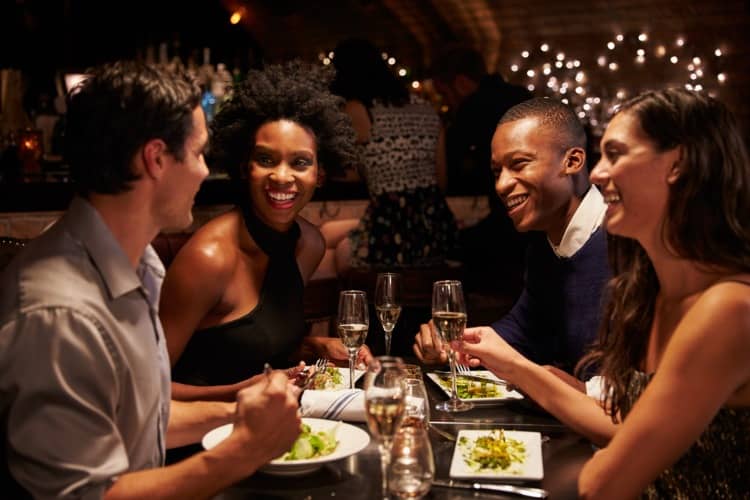 A group of people smiling and dining together