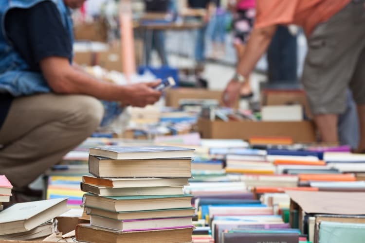 people looking through stacks of books at a san antonio book festival