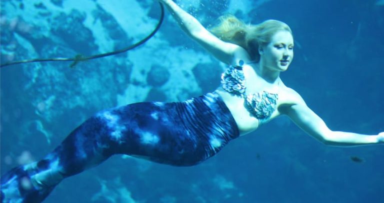 Woman dressed as mermaid swimming