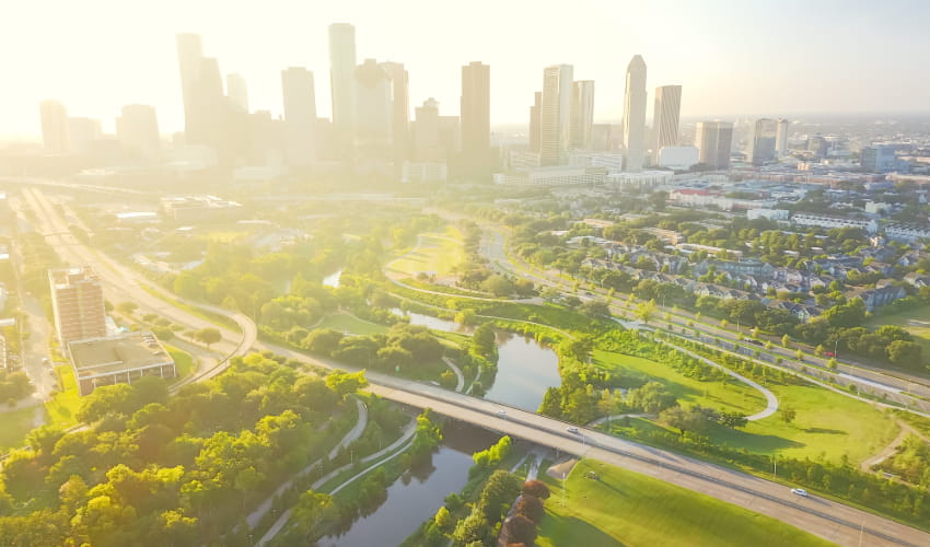 the sun rises over the Houston skyline