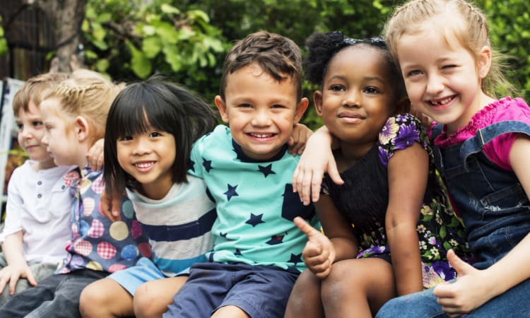 Kids sitting with arms around each other