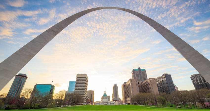 the Gateway Arch towers over the skyline and sunset in St Louis