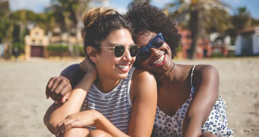 Two friends sitting on a beach together