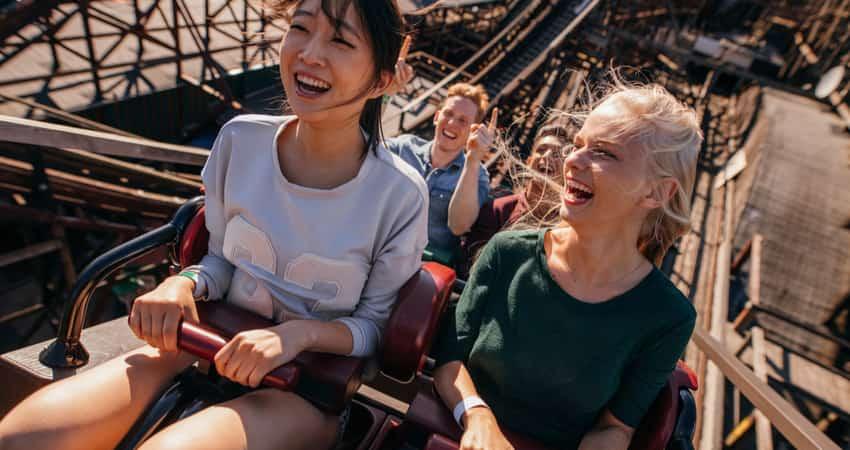 Friends smiling on a wooden roller coaster