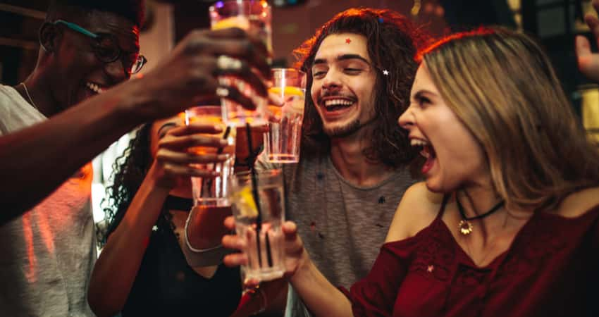 A group of friends toasting at a bar