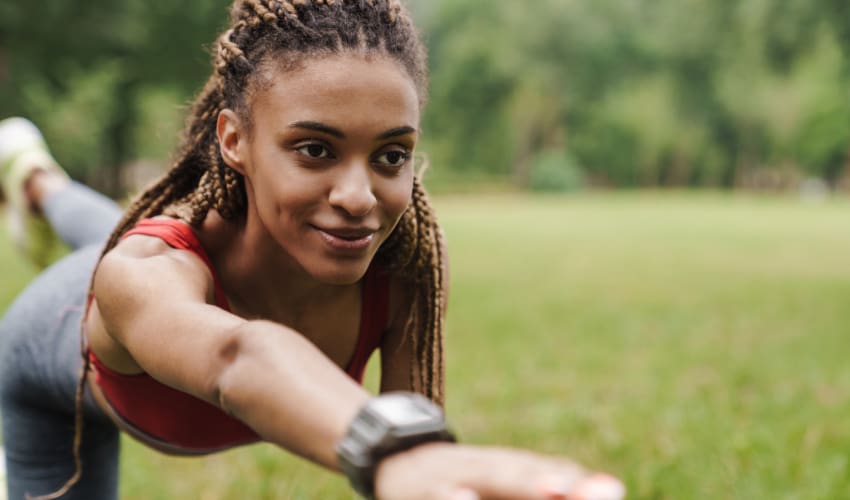 a lone woman does yoga in a grassy field