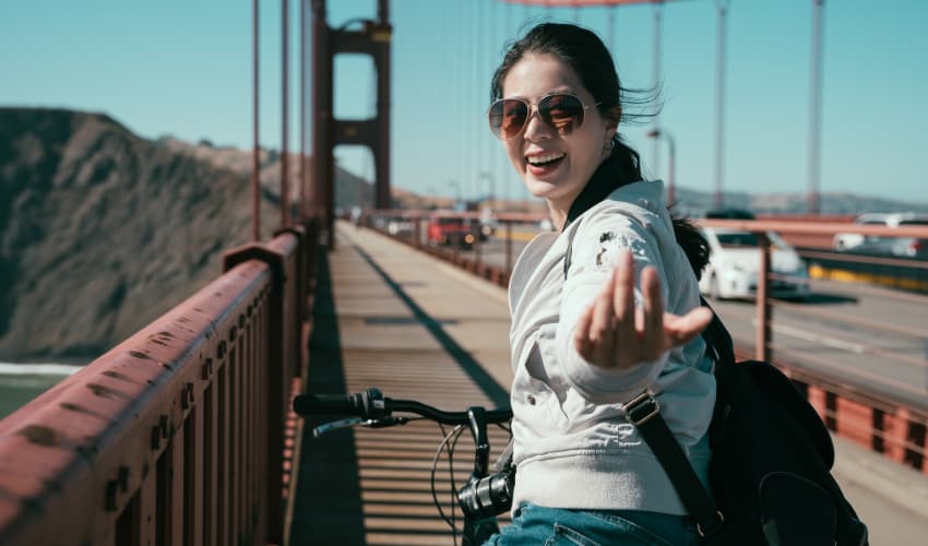 A woman on a bike crosses the Golden Gate Bridge