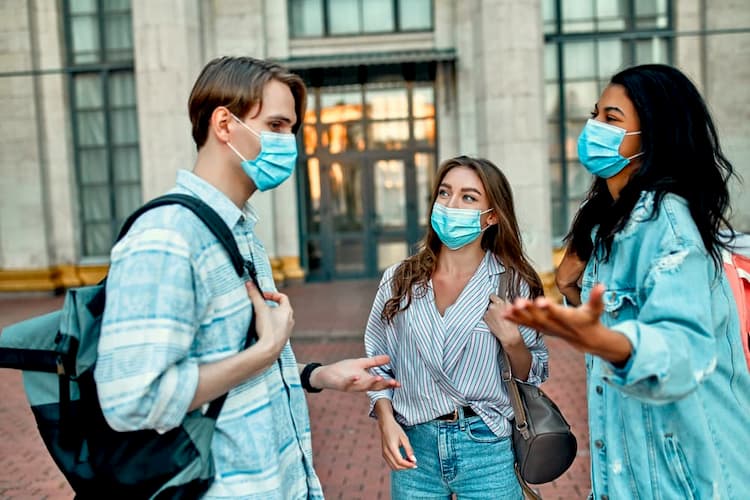 People wearing masks and talking outside