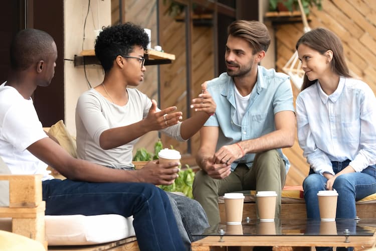 Friends talking over coffee on outdoor patio