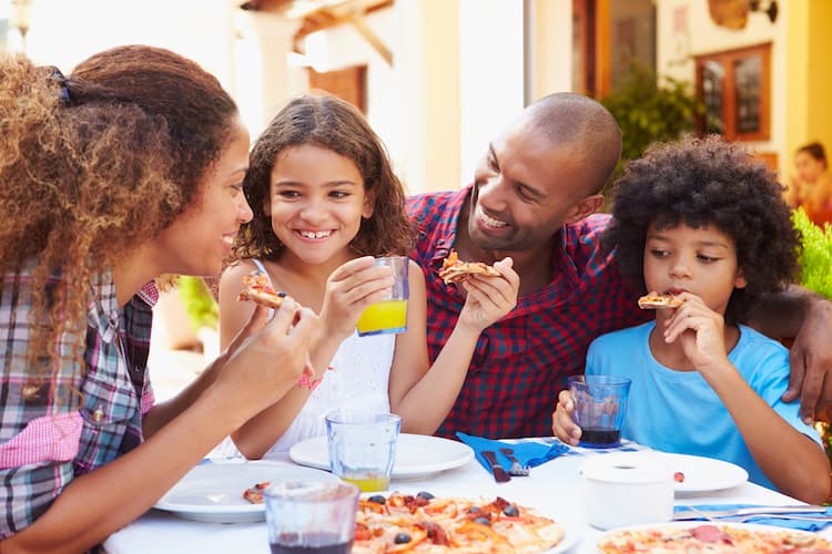 Family eating pizza on outdoor patio