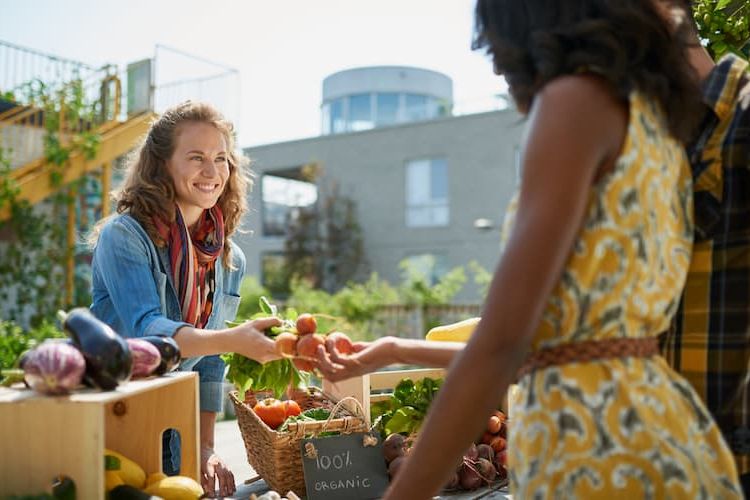 Woman helping out customer at farmers market