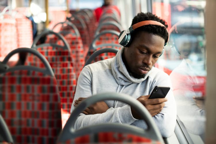Man looking at phone on bus