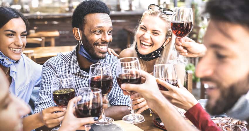 A group of friends toasting glasses of red wine