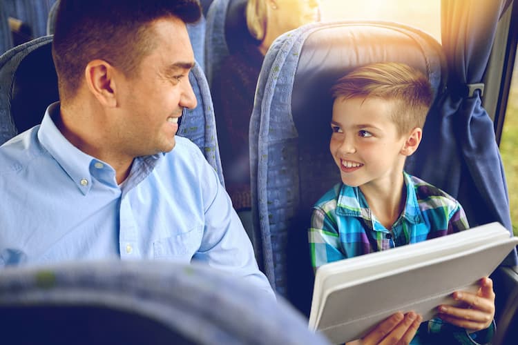 Son showing dad picture on a charter bus