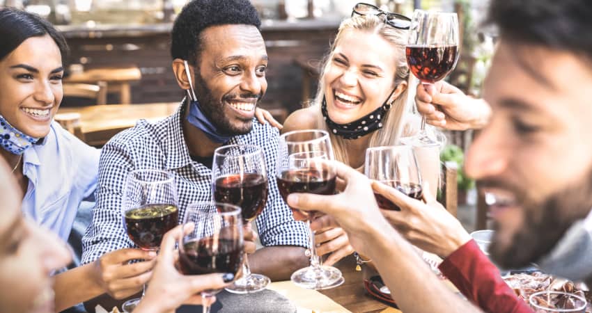 A group of friends toasting glasses of red wine