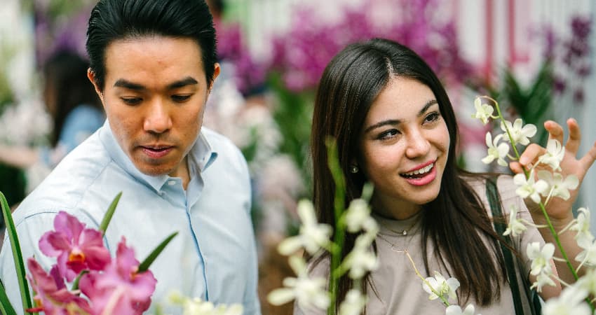 A young couple admire flowers in a botanical garden