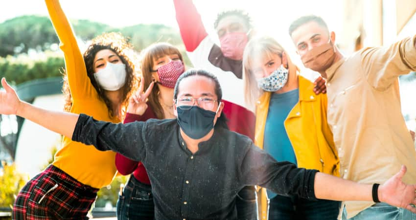 A group of friends outside wearing masks