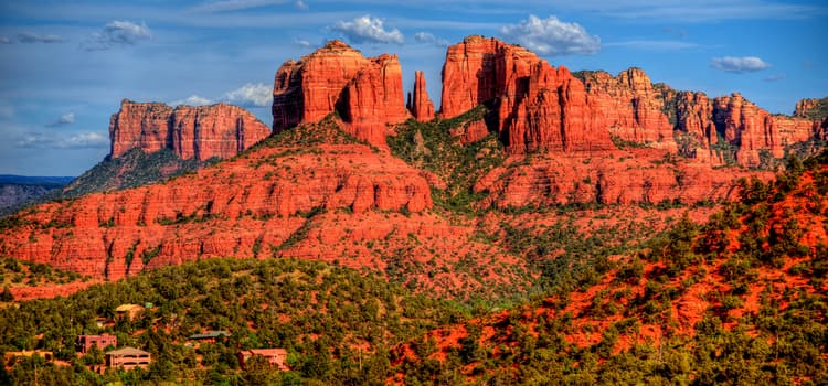 the red, rocky hillsides of sedona, arizona against a blue sky