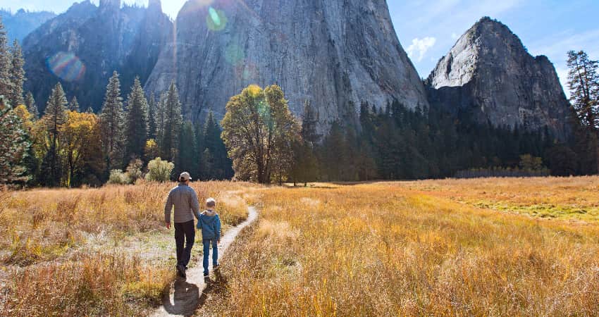 An adult and a child hike in Yosemite Valley