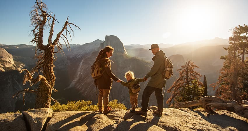 A family admires the view from a cliff in Yosemite National Park