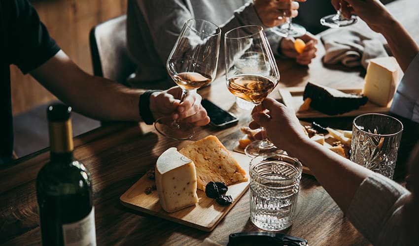 A group of friends taste wine at a vineyard