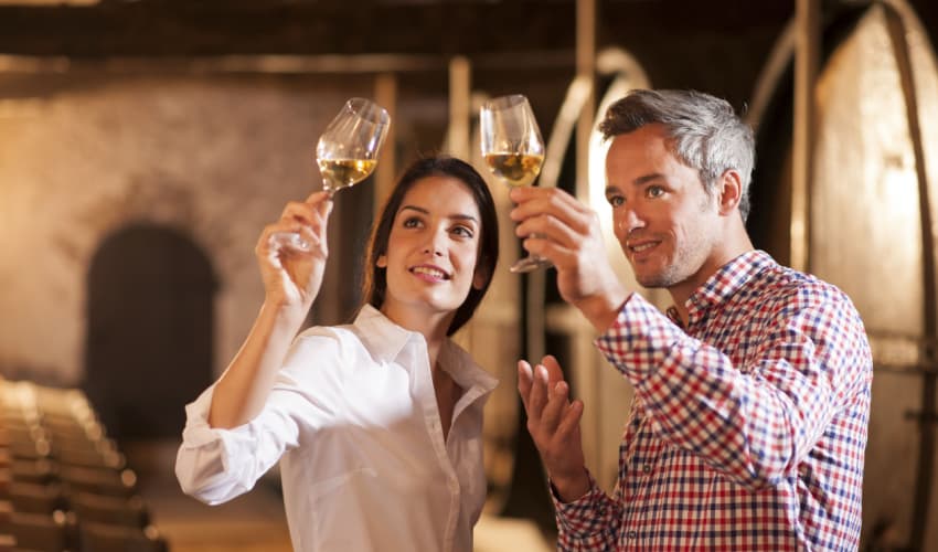 a couple looking a wine during a cellar tour