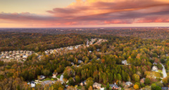 a view of suburban houses surrounded by trees with atlanta in the background