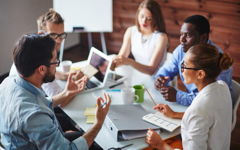 employees gather in a board room for a meeting