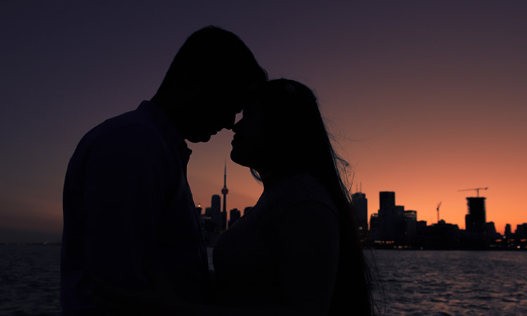 Bride and groom embrace in front of the Toronto skyline