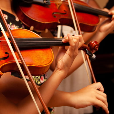 a closeup of violin performers' instruments