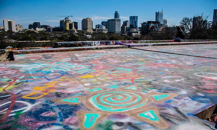 The Austin skyline visible over a rooftop mural