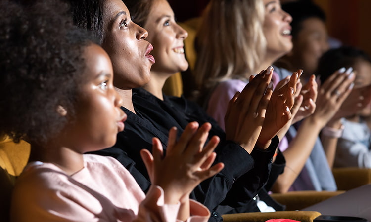 An audience applauds after a theatre performance