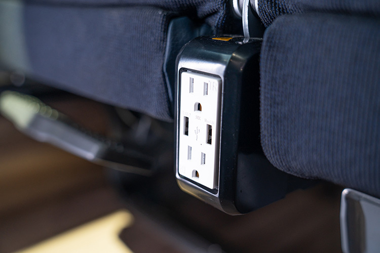 Power outlet between seats on a charter bus rental