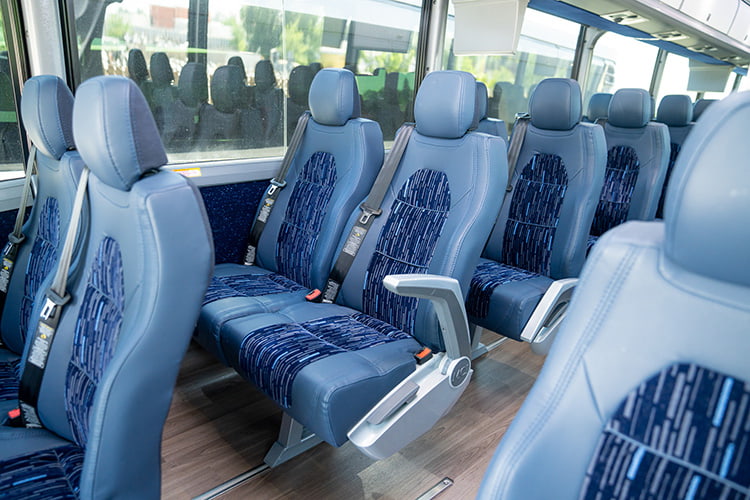 Charter bus interior with rows of plush seats